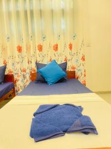 a bed with blue towels on top of it at Kenashi Green Villa in Weligama