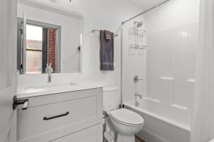 Un baño blanco con inodoro y lavabo. en Express Yourself! Stay in This Stylish Guest Fave!, en Saint Louis 5 fotos más