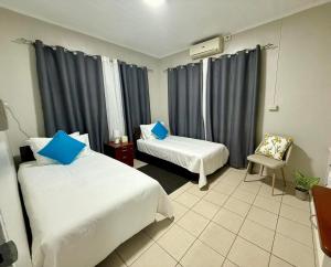 una stanza d'albergo con due letti e una sedia di 2 Bedroom Unit Near City Center a Suva