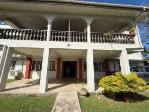 una casa bianca con un balcone sopra di 2 Bedroom Unit Near City Center a Suva