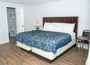 a bedroom with a large bed with a wooden headboard at Rainbow Motel in Douglassville