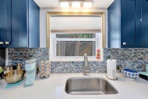 a kitchen with blue cabinets and a sink and a window at Treasure home in St-Pete Beach in St. Pete Beach +58 photos