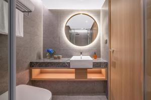 un baño con lavabo y espejo en Orange Hotel Beijing South Railway Station, en Beijing 21 fotos más