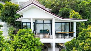 a white house with a balcony and trees at v5 Sea Breeze Home in Haad Yao