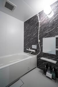 a bathroom with a bath tub and a mirror at Mks 102 in Asahikawa