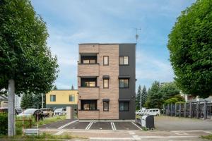 a tall wooden building in a parking lot at Mks 102 in Asahikawa