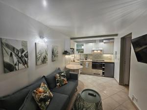 a living room with a couch and a kitchen at TropiKana in Evry-Courcouronnes +13 photos