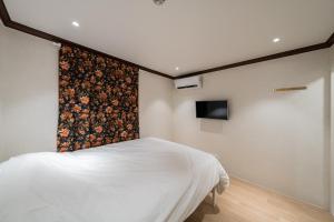 a bedroom with a bed with a floral accent wall at Life in Cheonggye in Seoul