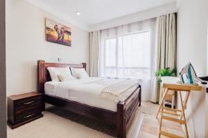 a bedroom with a bed and a desk and a window at Ultimate Safari Retreat,9min to Nairobi JKIA with Pool,Gym,WiFi and Binocular views in Nairobi +40 photos