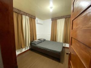 a small bedroom with a bed and a door at Cortes Rupertmel Fairways and Integrated Farm in Sampong