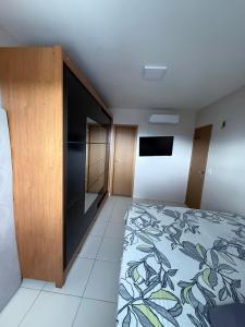 an empty room with a bed and a tv at Apt Completo Cop 30 in Belém