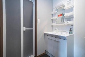 a white bathroom with a sink and a shower at Mks 102 in Asahikawa