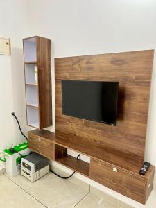 a flat screen tv on a wooden wall at Ayat Apartments - near to Rajagiri Hospital in Alwaye