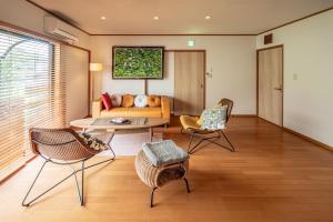 a living room with a couch and chairs at Imazu Garden House in Fukuoka