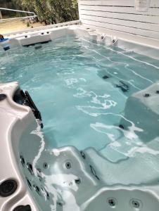 a bath tub with blue water in it at Family Beach House with Swim Spa in Nelson Bay