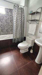 a bathroom with a toilet and a sink and a shower at Departamento acogedor in Abancay