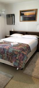 キングズコートにあるLodge on the Bay- now Backpacker's Price in Esplanade & Buller St Kingscote-Pay on arrivalの毛布がかけられたベッドのある寝室