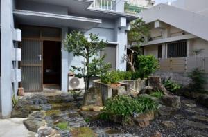 ein Haus mit einem Baum und Felsen davor in der Unterkunft Homa Ishigakijima no Yado - Vacation STAY 80173 in Ishigaki-jima