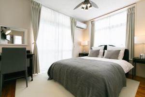 a bedroom with a bed and a desk and a window at Naha - House / Vacation STAY 79997 in Naha