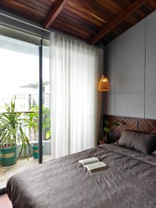 a bedroom with a large bed with a book on it at Local Charm Homestay in Thôn Trường Giang