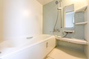 a bathroom with a tub and a sink and a mirror at Ryoan / Vacation STAY 80261 in Otaru +17 photos