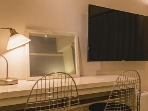 a room with two chairs and a desk with a mirror at Aiwa Mansion / Vacation STAY 80383 in Naha