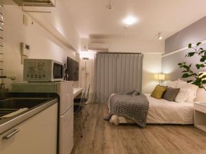 a hotel room with a bed and a microwave at Aiwa Mansion / Vacation STAY 80383 in Naha