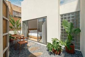 a balcony with a bed and a table and plants at Cholula Condesa Hotel by Lumina in Mexico City