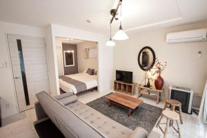 a living room with a couch and a bed at Premiere N21 / Vacation STAY 7452 in Sapporo