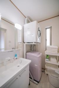a bathroom with a sink and a toilet and a mirror at Okinawa - House / Vacation STAY 80468 in Okinawa City