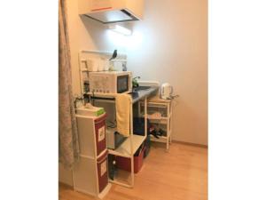 una cucina con un forno a microonde su uno scaffale con scatole di Sadie's Home / Vacation STAY 7575 a Kawasaki