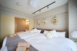 a bedroom with a large white bed with towels on it at Maison Etoile 706 / Vacation STAY 7561 in Nagoya