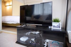 a large flat screen tv on a black entertainment center at Maison Etoile 706 / Vacation STAY 7561 in Nagoya