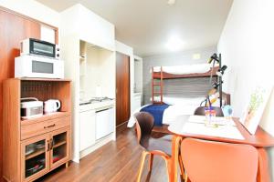 ein kleines Zimmer mit einem Bett und einem Tisch und Stühlen in der Unterkunft Heights N7 / Vacation STAY 7568 in Sapporo