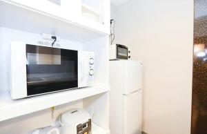 a microwave oven on a shelf in a kitchen at Suncourt Hondori Garden Hills / Vacation STAY 7587 in Sapporo