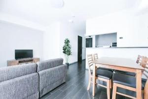 ein Wohnzimmer mit Sofa und Tisch in der Unterkunft Suncourt Hondori Garden Hills / Vacation STAY 7593 in Sapporo