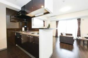 eine Küche mit einem Waschbecken und einem Sofa in einem Zimmer in der Unterkunft Suncourt Hondori Garden Hills / Vacation STAY 7593 in Sapporo