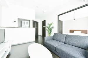 Suncourt Hondori Garden Hills / Vacation STAY 7592 في سابورو: غرفة معيشة بها أريكة وسرير