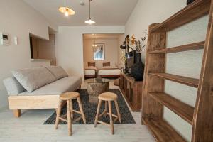 a living room with a couch and two stools at Premiere N21 / Vacation STAY 7450 in Sapporo