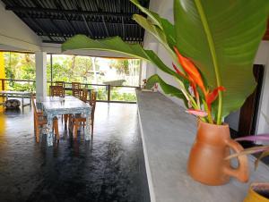 a dining room with a table and a vase with flowers at Anara Villa in Unawatuna