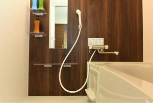 a bathroom with a bathtub with a hose connected to a mirror at Hills Garden Hondori / Vacation STAY 7577 in Sapporo +59 photos