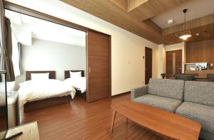 a living room with a bed and a couch at Hills Garden Hondori / Vacation STAY 7577 in Sapporo