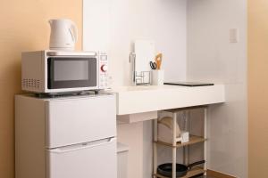 a kitchen with a microwave on top of a refrigerator at BEYOND HOTEL Takayama 3rd - Vacation STAY 82215 in Takayama +4 photos