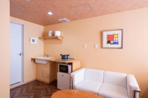 a living room with a white couch and a table at BEYOND HOTEL Takayama 2nd - Vacation STAY 82265 in Takayama