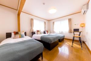 Habitación con 2 camas y escritorio. en Minamitsuru-gun - House - Vacation STAY 82283, en Fujikawaguchiko