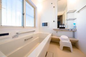 ein weißes Badezimmer mit Badewanne und Hocker in der Unterkunft Minamitsuru-gun - House - Vacation STAY 82324 in Fujikawaguchiko