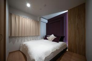 a bedroom with a white bed with a large window at Minamitsuru-gun - House - Vacation STAY 82353 in Fujikawaguchiko