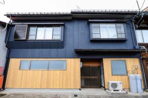 a blue house with a wooden door and windows at BEYOND HOTEL Takayama 4th - Vacation STAY 82226 in Takayama