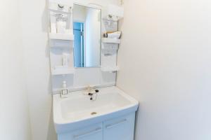 un baño con lavabo y espejo en Bijou Suites Sorriso - Vacation STAY 7862, en Osaka 45 fotos más
