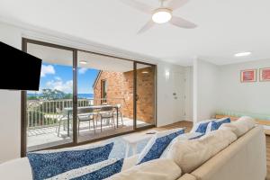 Una sala de estar con un sofá y un balcón. en Pacific Gables 8, en Gold Coast
